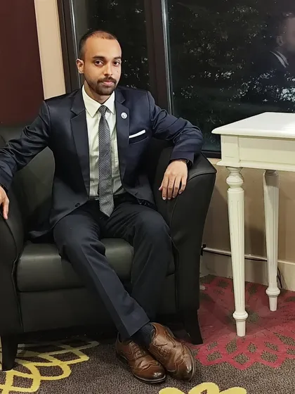 A formal portrait reflecting the serious and focused mindset required for both martial arts and professional speaking.