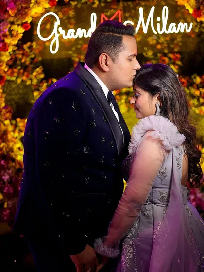 A sweet forehead kiss against a "Grand Milan" neon sign. This engagement photo is both tender and stylish, capturing the essence of the celebration.