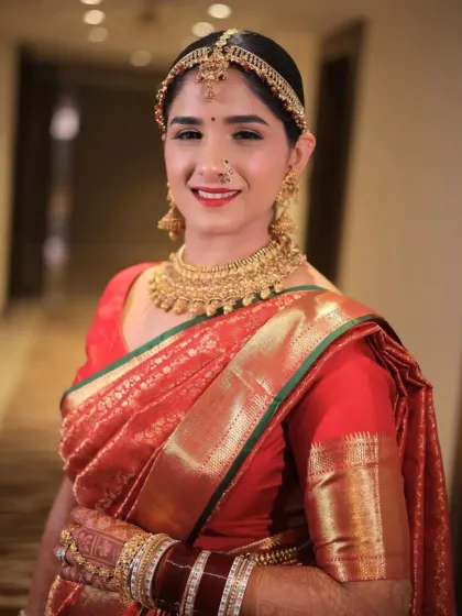 A close-up portrait of the smiling bride. Her makeup is clean and fresh, with a bold red lip that adds a pop of color to her look.