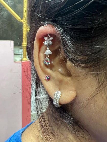 A multi-layered hanging with butterfly and jhumka elements, creating a very intricate and unique look.