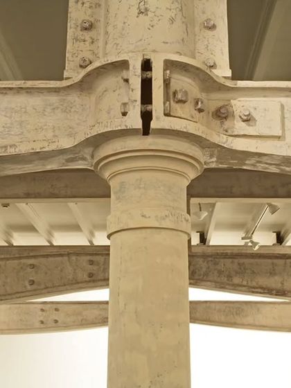 A detail of a restored cast-iron column and steel beam connection at Project 88 gallery. We celebrate the industrial heritage of the buildings we adapt, making the original structure a key part of the architectural experience.