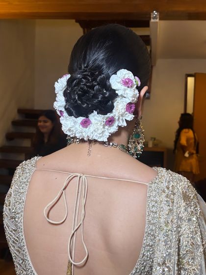 Another perspective of the detailed floral bun. The placement of small pearls within the woven hair adds a subtle touch of glamour, a finishing detail we focus on in class.