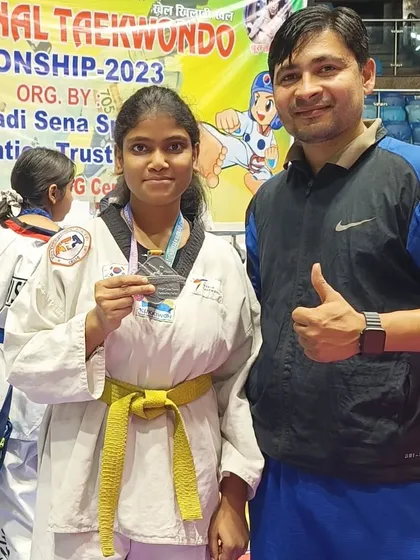 A female student with her silver medal, a result of her consistent training.