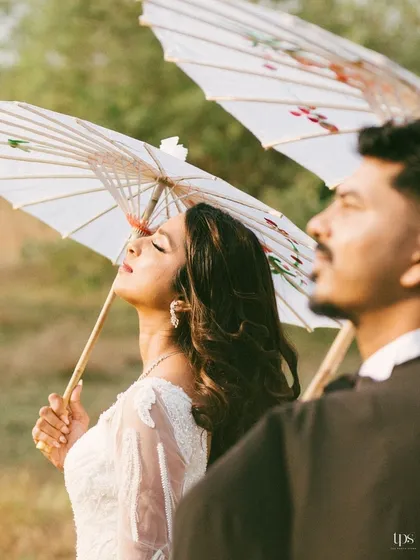 Frenzita and Abner in a serene, sun-drenched moment. The use of traditional parasols adds a touch of elegance and artistry to this outdoor pre-wedding portrait.