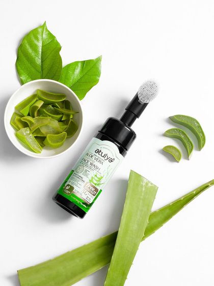 A clean, top-down shot of an aloe vera face wash with fresh aloe slices. The white background makes the green elements pop, creating a fresh and natural look.