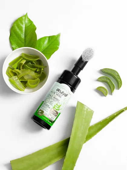 A clean, top-down shot of an aloe vera face wash with its key ingredients. This type of deconstructed shot is excellent for clearly communicating the natural and fresh components of a product.