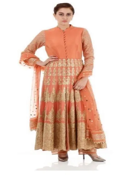 This peach and gold Anarkali set showcases traditional craftsmanship with a contemporary feel. The high-neck collar, full sleeves, and intricate gold patterns make it a regal and sophisticated option for weddings and traditional functions.