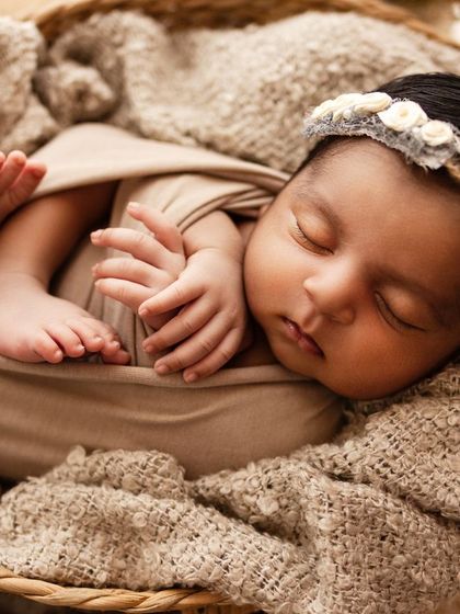 Pure innocence. This newborn is curled up in a basket, looking so peaceful and content. The neutral tones are calming and classic.