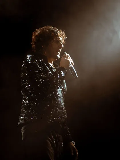 A portrait of the legendary Sonu Nigam, isolated by a single spotlight. This artistic shot focuses on the quiet intensity and emotion of the artist just before he delivers a powerful note.