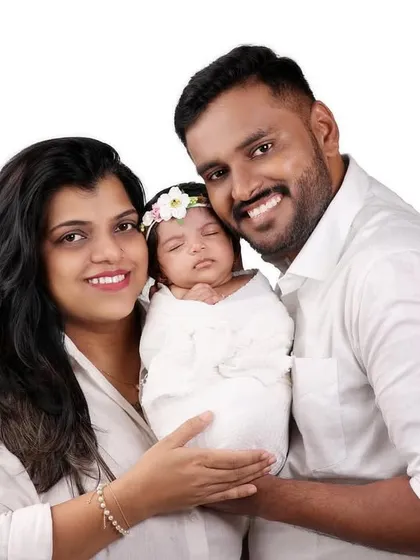 A classic family portrait with a newborn, shot on a clean white background for a timeless look.