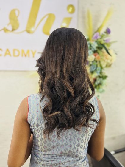 A full back view of the completed curly hairstyle, showing how the waves fall naturally. This is a foundational look for many modern bridal and party hairstyles.