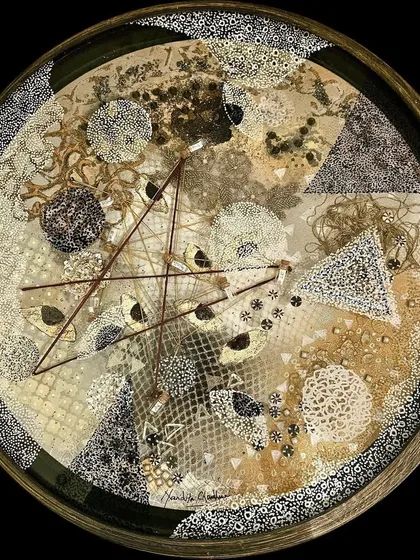 This circular work by Nandita Chaudhuri features thread-work geometry and earthy materials, grounding the celestial feel of the piece, on view at 'On The Go.'