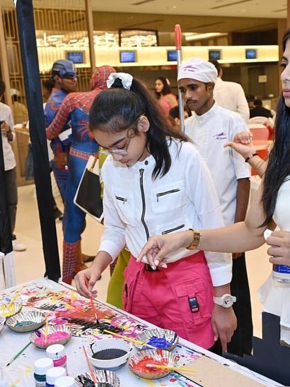 Guests enjoying the spin art station, another creative activity we set up. You can see Spider-Man in the background, checking in on the fun.