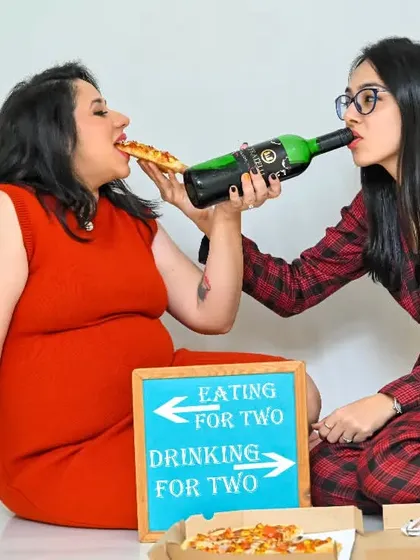 "Eating for two, drinking for two!" A hilarious and unique studio shot that perfectly captures a couple's sense of humor about the pregnancy journey.