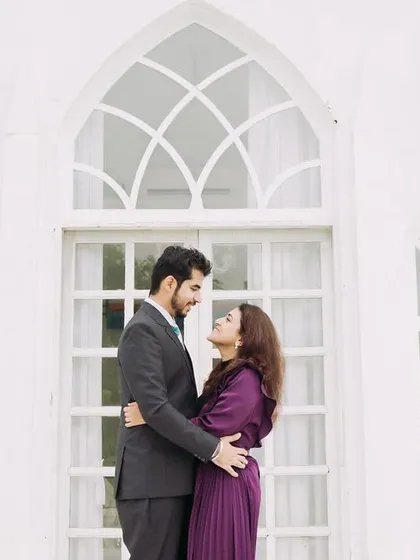 An elegant portrait in front of a white chapel-style building. This backdrop adds a touch of classic romance and sophistication to the pre-wedding shoot.