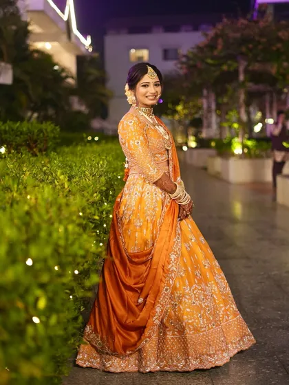 Vibrance in the outfit, elegance in the glow. We kept it simple with subtle glam to let this stunning orange lehenga steal the show.
