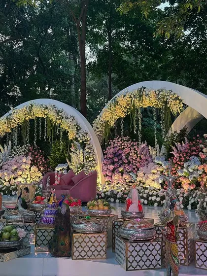 A wider view of the three floral arches in the garden setting.