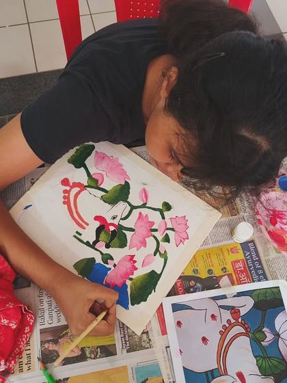 A student deeply engaged in painting the delicate lotus flowers, a common motif in Pichwai art. We provide reference images and all materials to help bring these traditional scenes to life.