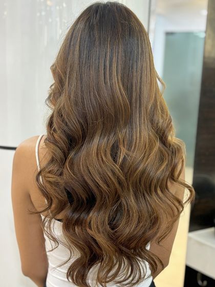 A full view of our Caramel Balayage, showcasing the seamless blend from a darker root to lighter, caramel-toned ends.