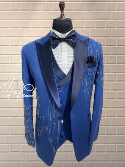 This royal blue tuxedo is designed to stand out. It features cascading silver beadwork on the jacket, adding a touch of sparkle and glamour for a reception or cocktail party.