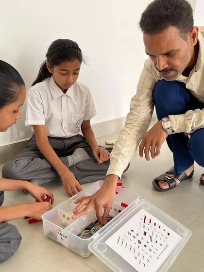 An instructor provides close guidance to two students at SVIS, ensuring they understand the task and are on the right track.