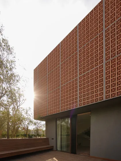 The Lantern House is a project where we transformed an existing structure into a private sanctuary. The signature terracotta 'jaali' screen acts as a protective veil, shielding the home from the harsh sun while creating a beautiful, glowing effect at night, embodying our approach to modern vernacular architecture.