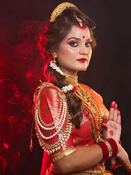 A graceful pose of the Maa Chandraghanta look, with dramatic red lighting enhancing the mood.
