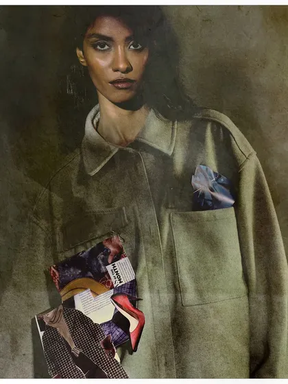 A portrait from the 'from the pages' series where a collage of magazine clippings is attached to the model's jacket. The moody lighting and direct gaze add to the narrative about fashion's influence.