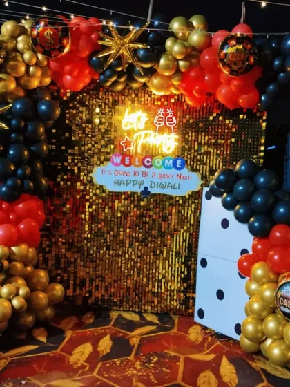 Another angle of the casino party decor, highlighting the vibrant red, black, and gold balloon arch.