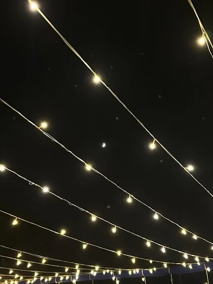 Sometimes, the simplest things are the most beautiful. A canopy of fairy lights against the night sky, creating a magical atmosphere for any intimate gathering.