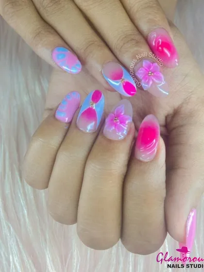 A playful and vibrant set combining a pink-to-nude ombré with blue and pink abstract art. The look is finished with delicate, hand-sculpted 3D pink flowers, adding a touch of softness to the bold design.