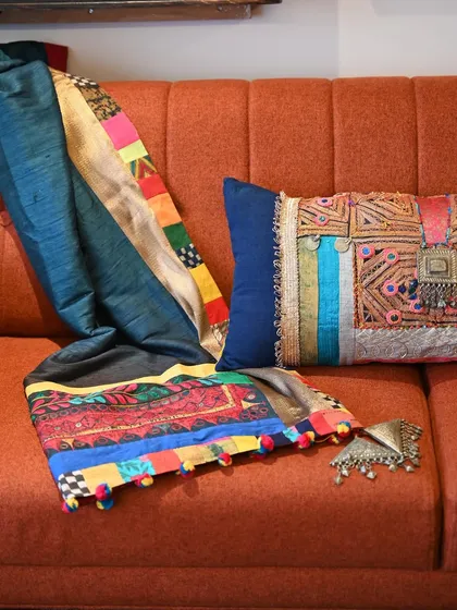 A custom set featuring a Banjara throw and a matching lumbar cushion, created to bring a festive and colorful energy to a living space. I embellished the vibrant vintage Banjara textile with details from my collection of old jewelry, coins, and handmade tassels, transforming it into a modern heirloom.