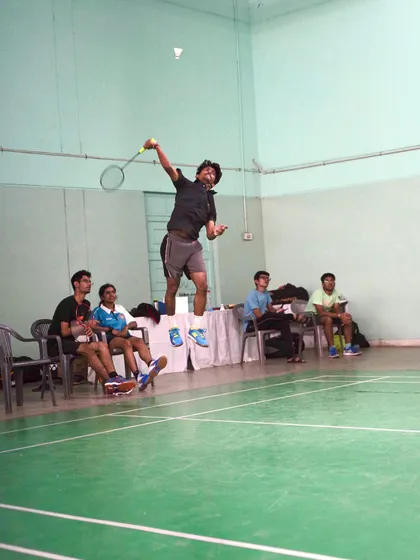 This photo captures the intense focus and physical effort of a player executing a jump smash over the net.