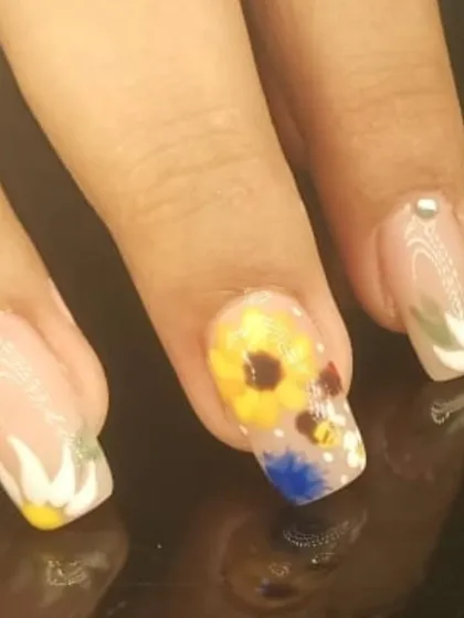 A close-up of the detailed, hand-painted sunflower accent nail.