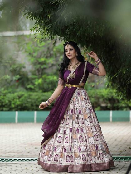 A dynamic shot of the model in motion, showing the beautiful flow and design of her traditional printed lehenga.