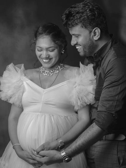 A candid black-and-white shot filled with genuine laughter. Capturing these unposed moments of joy is a key part of my approach to couple's maternity photography.