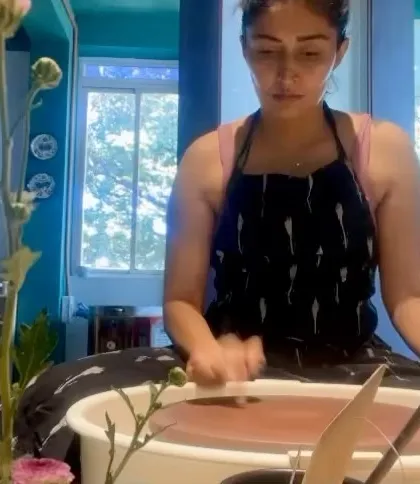 The same student, deep in concentration while throwing. Her journey from client to potter shows how a passion for ceramics can turn into a hands-on skill.