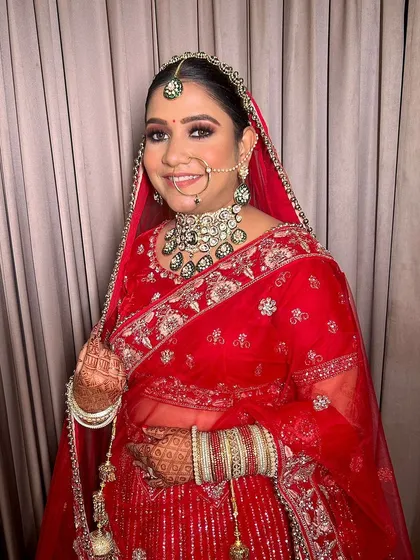 The bride is all smiles, looking confident and beautiful. The makeup is set to last through the entire wedding day, from the ceremony to the reception.