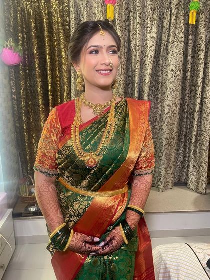 Capturing the beauty of tradition with this stunning Puja look for a pre-engagement ceremony. The bride looks absolutely radiant in her green and red silk saree.