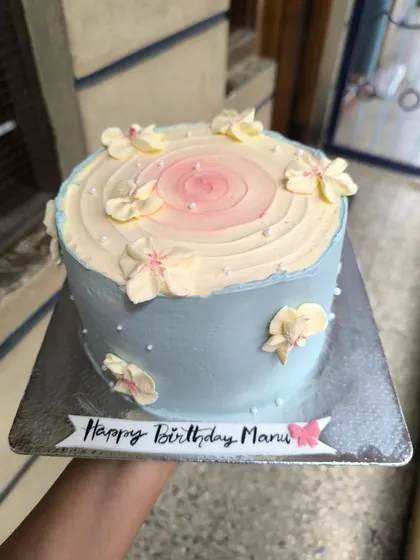 The color palette, the design, the florals, everything about this cake is a check. A beautiful pale blue cake with a pink center and delicate piped flowers.
