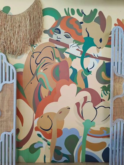 Another section of the Balinese-themed mural, showing how it interacts with the restaurant's architectural details.