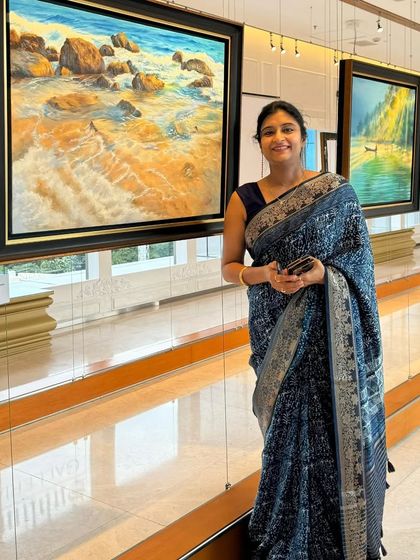 Artist Rashmi Soni posing with one of her serene beachscape paintings.