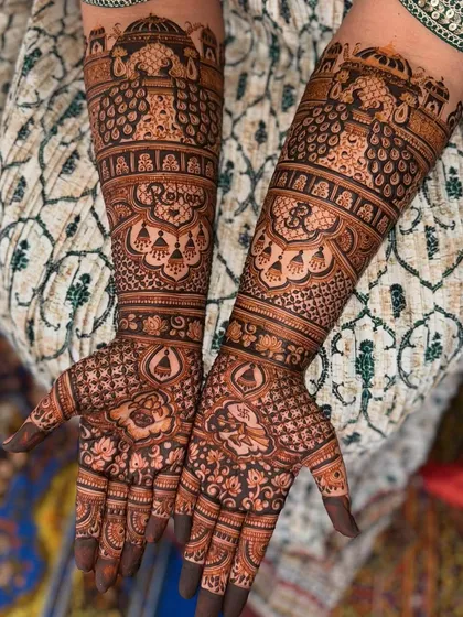 For the bride who wants it all, I create heavy, full-coverage bridal mehendi. This design is packed with detail, featuring peacocks, domes, and floral patterns that extend up the arm for a truly grand statement.