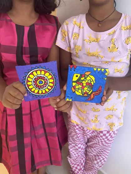 Students showing off their hand-painted coasters from our Dussehra workshop. We learned Madhubani-style painting to create these unique and functional art pieces.