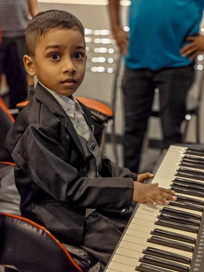 This young student, dressed up and ready to perform, perfectly captures the spirit of our academy. We build confidence and a love for music from the very first lesson.