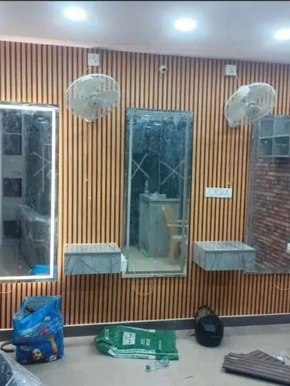 My work isn't just for homes. I transform commercial spaces to make brands unforgettable. Here, I used modern louvered wood panels and custom-lit mirrors to give this Bangalore salon a high-end, professional look that attracts and retains clients.