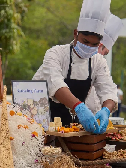 A chef carefully assembles a grazing board at a destination event. Even when we are miles from home, our team brings the same level of precision and artistry to their work.