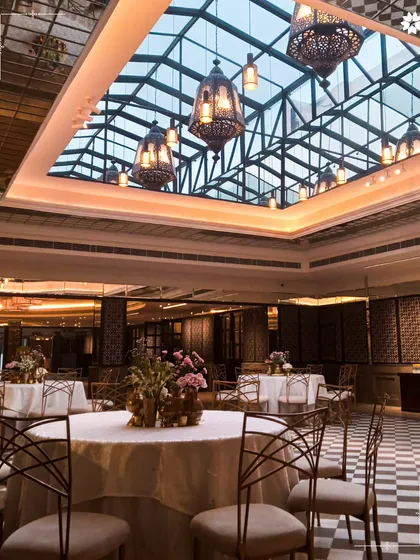 The beautiful glass ceiling and Moroccan style lanterns at Araya Bagh in New Delhi. This unique architectural feature provides a stunning atmosphere for evening events.