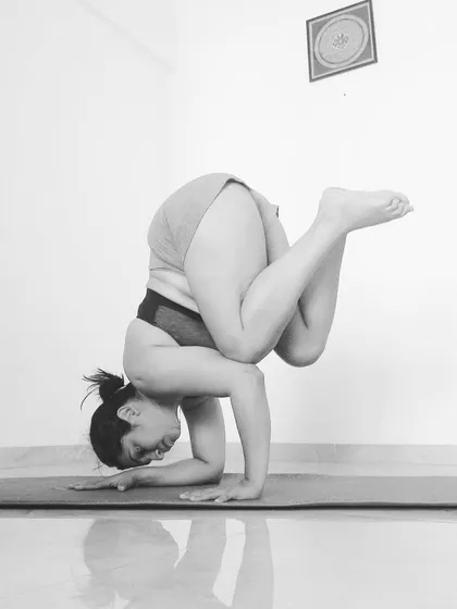 A close-up of the tucked Pincha pose, showing the engagement in the shoulders and core.