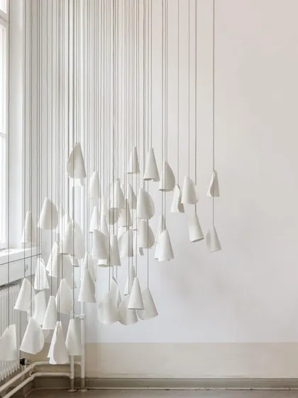 An installation of unlit Bocci 21 pendants, emphasizing their delicate, paper-like forms. The arrangement creates a beautiful play of shapes against the clean white walls.